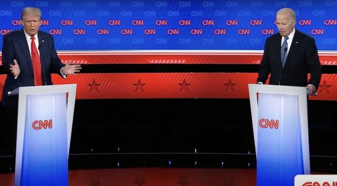 U.S. President Biden and Trump debate issues like immigration, border security and more from behind podiums on a stage.