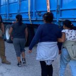Two women and a child walk toward INM agents in Mexico