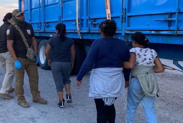Two women and a child walk toward INM agents in Mexico