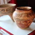 Closeup of an ancient Maya vase with red figures painted on clay