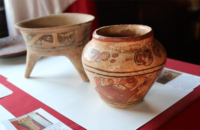 Closeup of an ancient Maya vase with red figures painted on clay